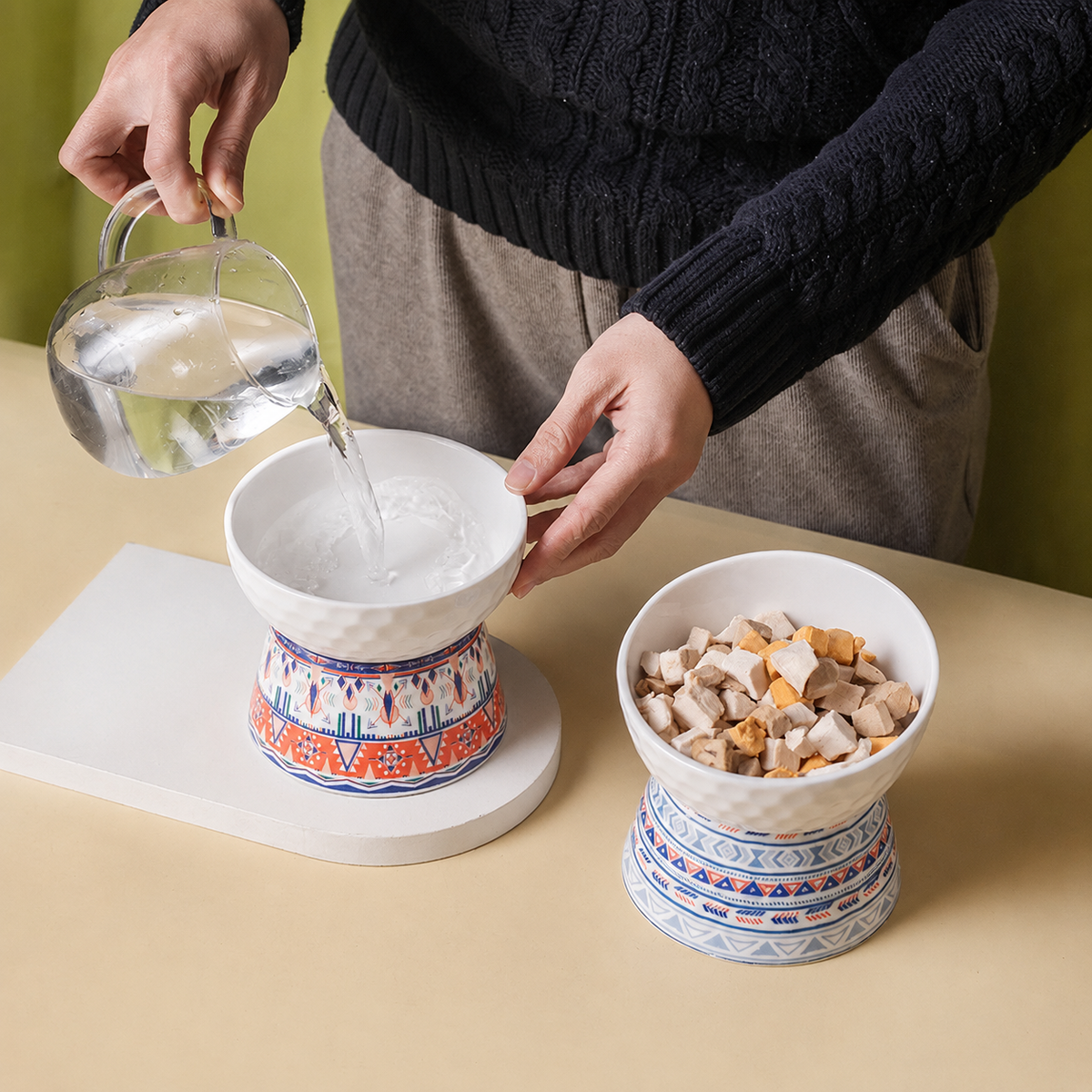 Deux gamelles surélevées en céramique Hachimi à motifs bohèmes, l’une remplie d’eau et l’autre de nourriture pour chat.